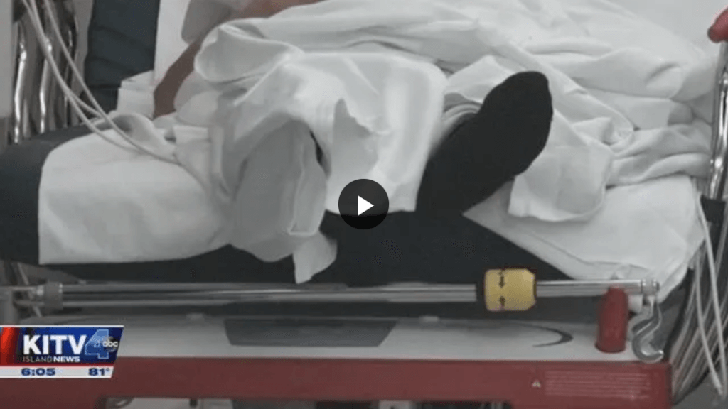 Foot of hospital patient sticking out from under blankets