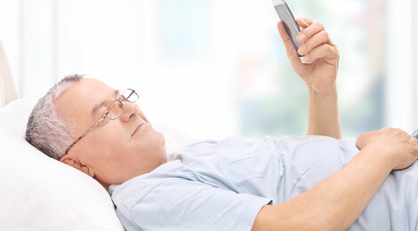 Man in bed using mobile device