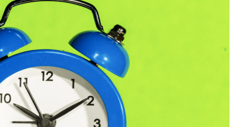 Blue alarm clock with green background