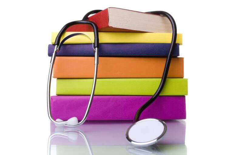 Stack of colorfull books with a stethoscope draped over them