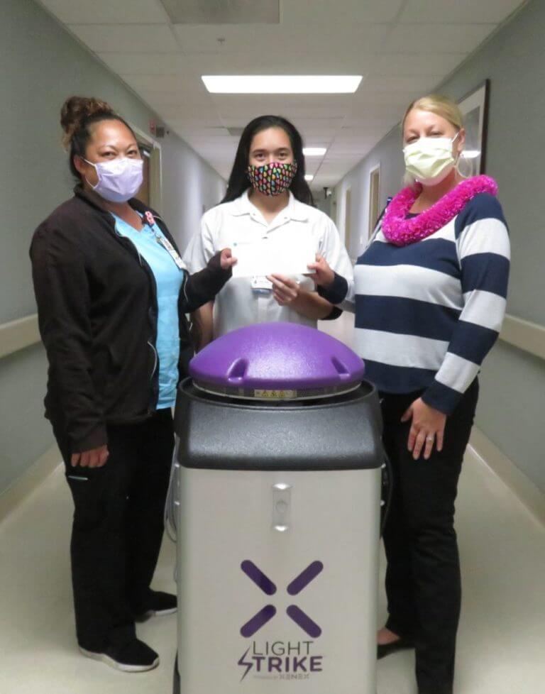 QHS staff stand with Winner, the robot cleaner from Light Strike