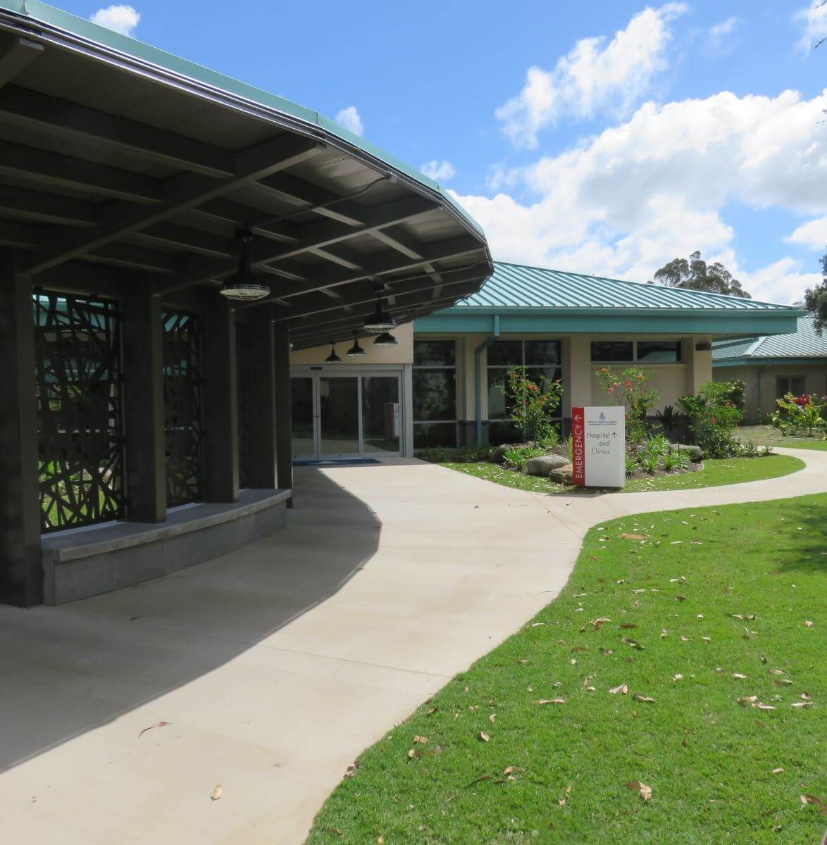 Path leading up to ER with grass and an architectural awning.