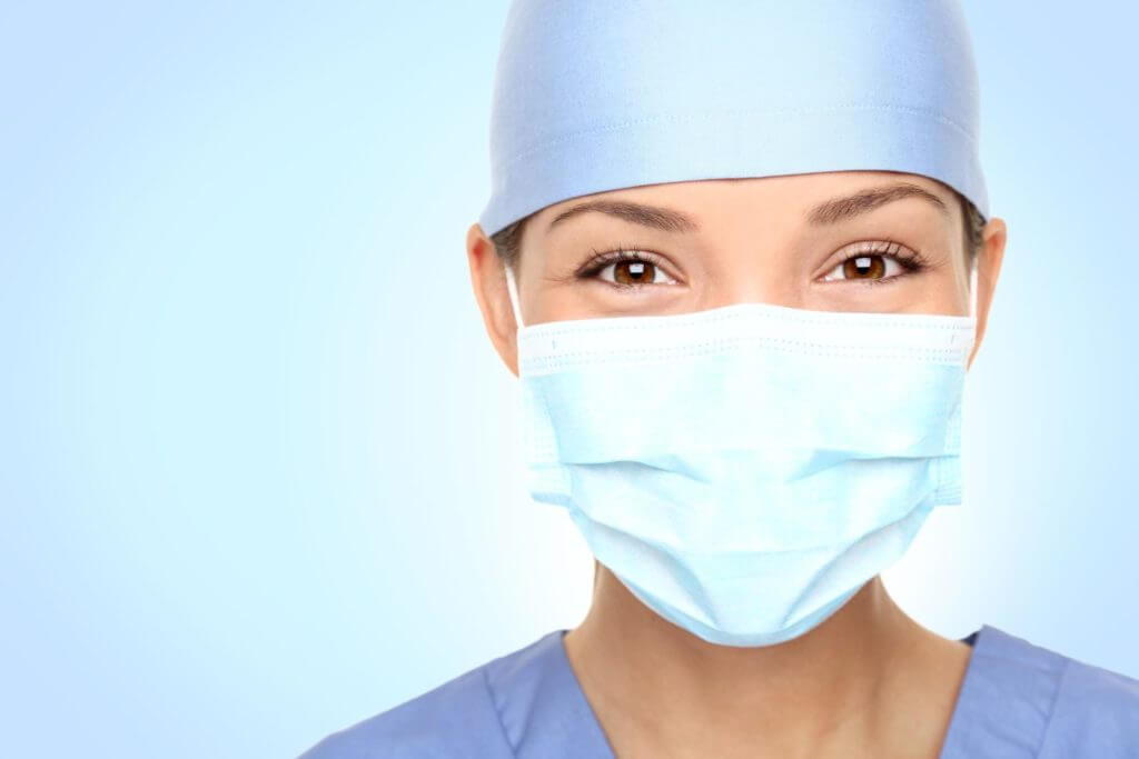 Close up of a female surgery staff in cap and face mask.