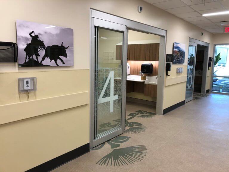 New ER with flora pattern on floor, large graphic numbers for each room, and image of cowboy roping a bull.
