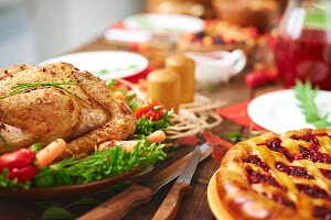 Turkey and cherry pie on a table decorated with fall items.