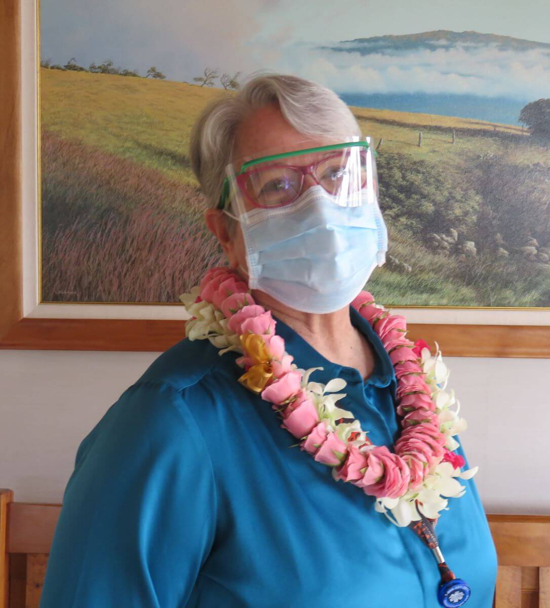 Portrait of Social Worker Corey McCullough wearing leis after being recognized as Employee of the year