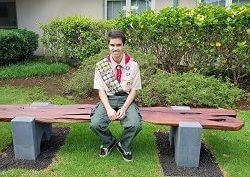 Eagle Scout Chavis Arafiles sitting in park where his uniform.
