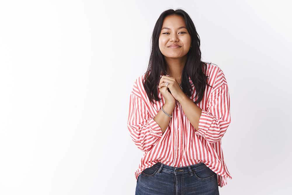 Young adult woman in red blouse and jeans.