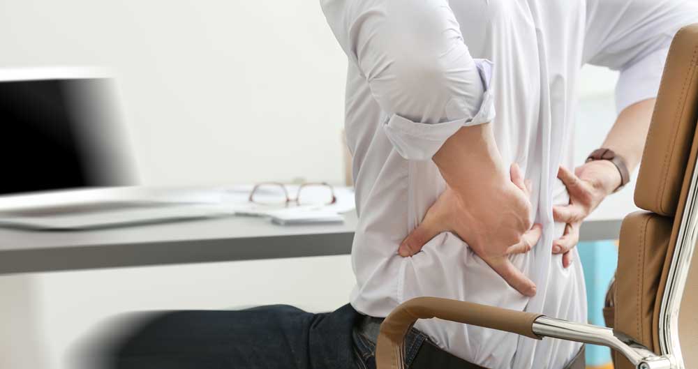 Close up of man holding his lower back in pain.