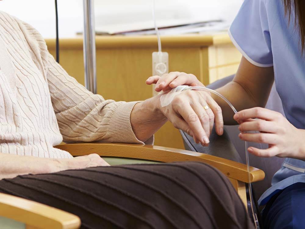 Close up of patients hand hooked up to chemotherapy drip.