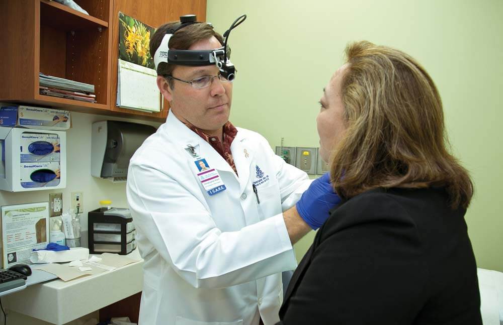 Doctor examines woman's throat and jawline