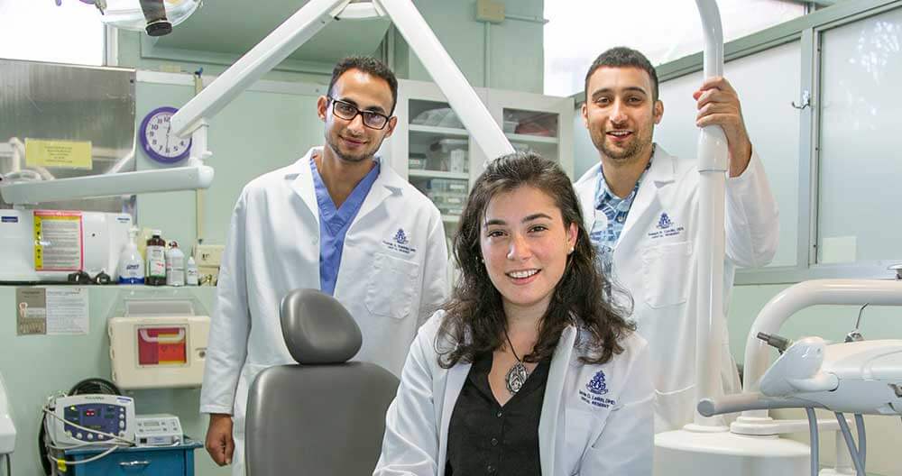 3 Dental residents standing with dental equipment