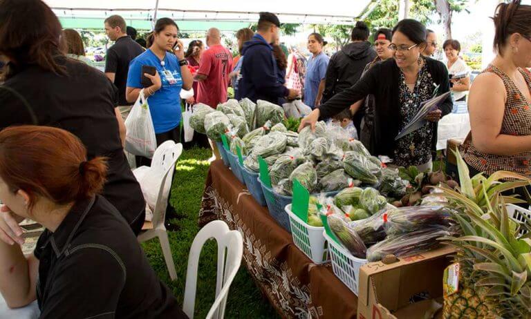 Stall of vegetables at a busy farmers market