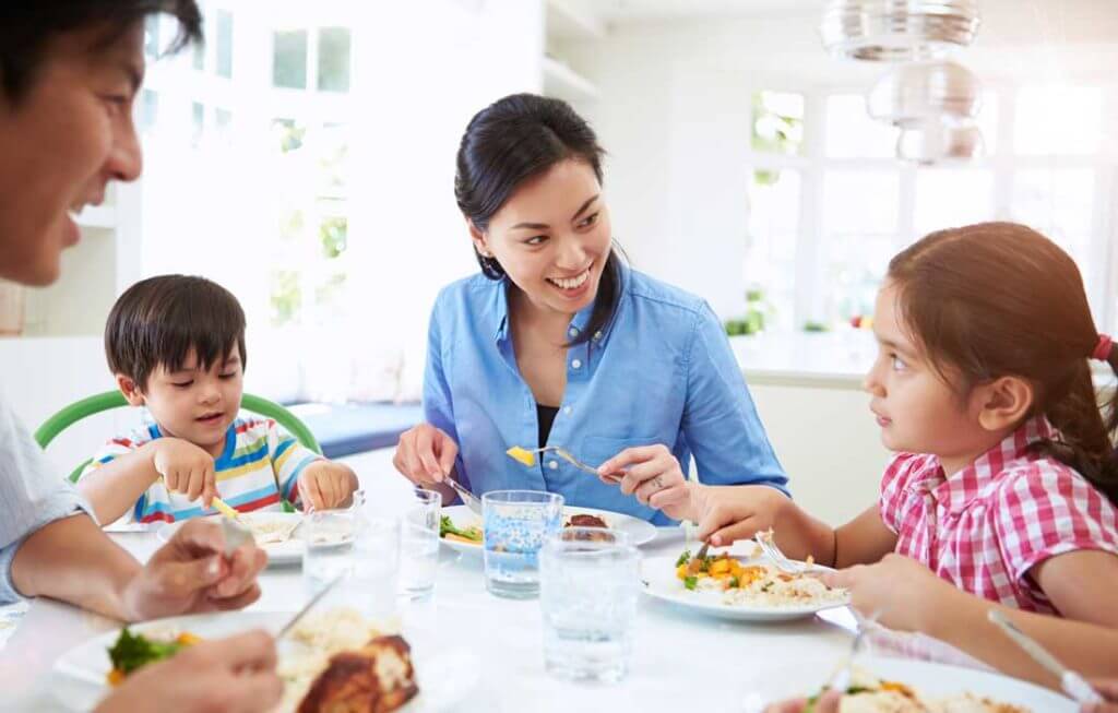 Family of 5 eating a healthy dinner together.