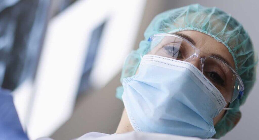 Close up of female surgeon looking down and making eye contact with the camera.